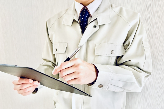 クリップボードを持つ作業服のビジネスマン