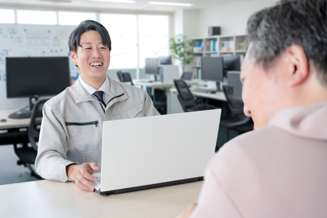 オフィスで相談を受ける作業服の男性