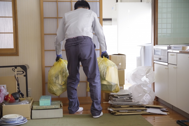 和室でゴミ袋を持つ人の後姿